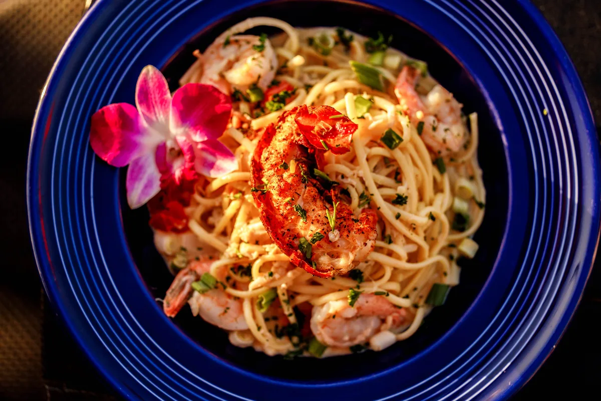 Tutto Mare seafood pasta with shrimp on a blue plate