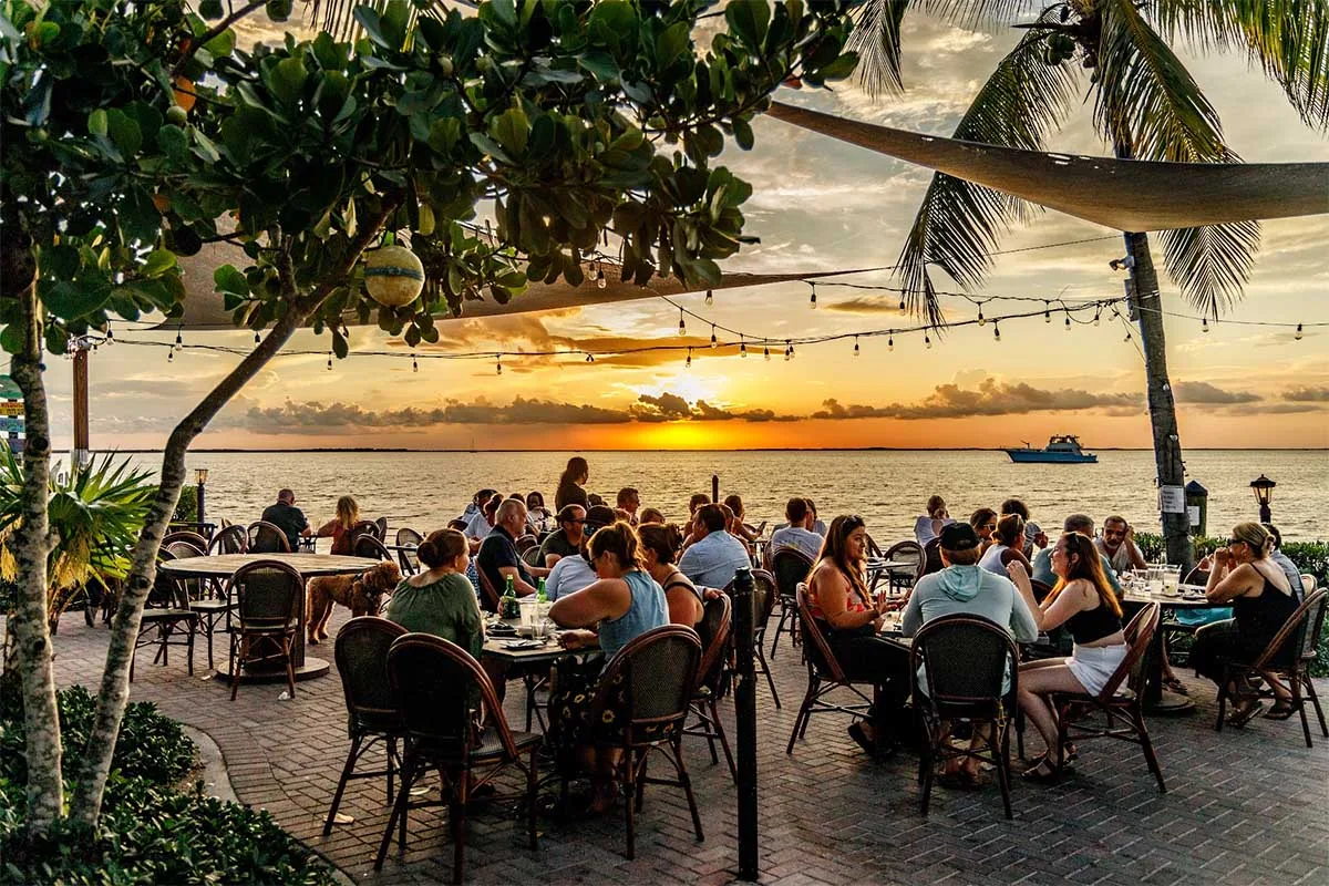 Guests dining beside Florida Bay at sunset